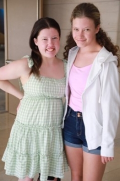  Photograph by Rick Guidotti featuring two young women, smiling, and looking at the camera. These woman live with rare disease. 